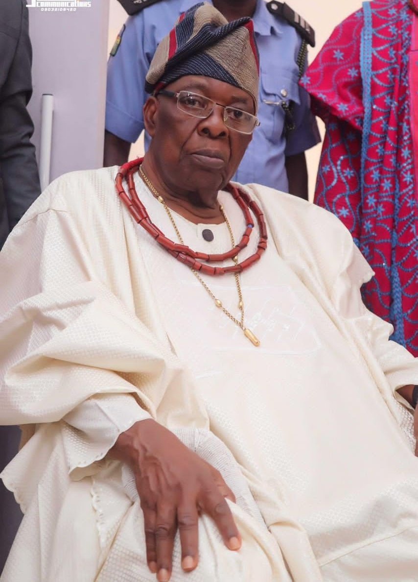 Oba Aromolaran II seated in cream traditional attire and coral beads