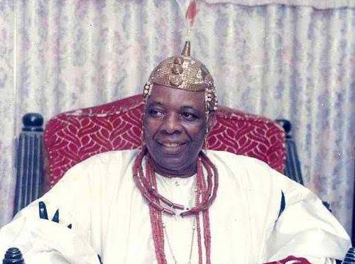 A younger Oba Aromolaran II smiling while seated in ceremonial attire